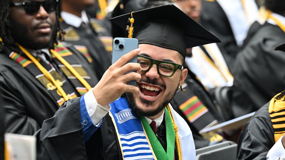 Graduate using his cell phone
