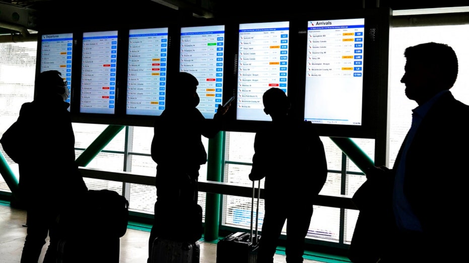 Travelers check American Airlines flight information at O'Hare International Airport