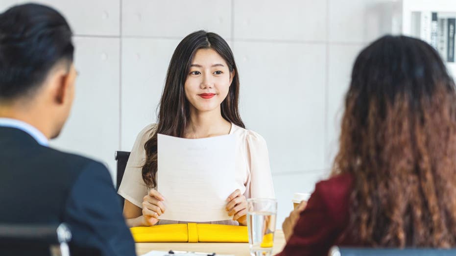 Woman sits at interview desk