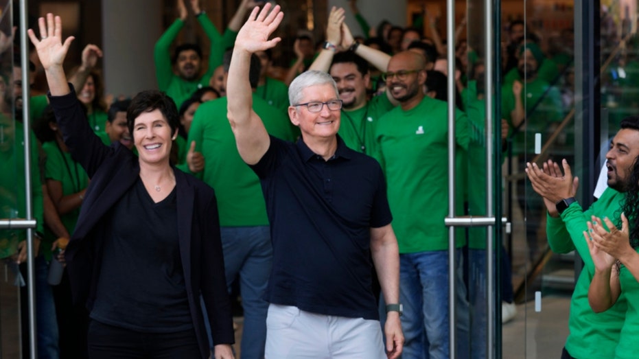Apple CEO Tim Cook waves to India shoppers